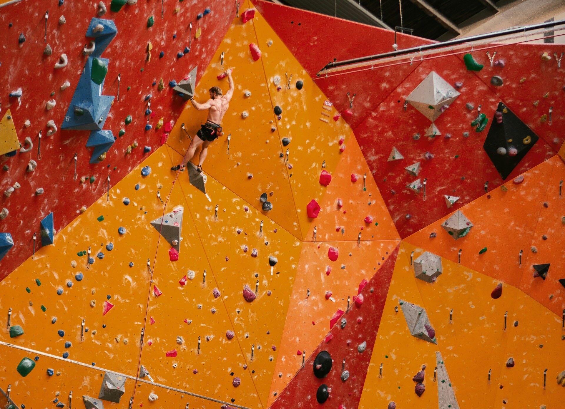 Climber ascending an indoor climbing wall